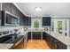 Well-lit kitchen features stainless steel appliances and sleek black cabinetry with granite countertops at 5900 Holly Dr, Raleigh, NC 27616