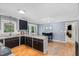 Bright kitchen featuring dark cabinets, a granite countertop island, and hardwood floors at 5900 Holly Dr, Raleigh, NC 27616
