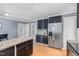 Well-lit kitchen featuring dark cabinetry, stainless steel appliances, and granite countertops at 5900 Holly Dr, Raleigh, NC 27616
