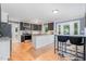 Open-concept kitchen with granite counters and a breakfast bar merges with a dining area at 5900 Holly Dr, Raleigh, NC 27616