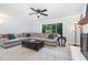 Cozy living room with a large sectional sofa, ceiling fan, and a view of the outdoors at 5900 Holly Dr, Raleigh, NC 27616
