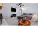 Bright living room with a fireplace, neutral carpet, a large sectional sofa and a dark ceiling fan at 5900 Holly Dr, Raleigh, NC 27616