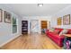 Inviting living room with hardwood floors, a comfortable red couch, and ample natural light at 5900 Holly Dr, Raleigh, NC 27616
