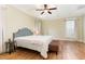 Bright bedroom boasts a coffered ceiling with ceiling fan, hardwood floors, and a padded headboard at 6 Tulip Tree Ct, Durham, NC 27712