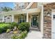 Inviting front porch with decorative landscaping and a charming entrance with decorative wreath at 6 Tulip Tree Ct, Durham, NC 27712
