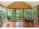 Screened porch with wood flooring offers views of the wooded area behind the property at 6 Tulip Tree Ct, Durham, NC 27712
