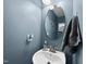 Stylish powder room with blue walls, decorative mirror and sink at 605 Smallwood Dr, Durham, NC 27703