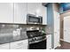 Close up of a stainless steel oven and microwave in a kitchen with white cabinets at 605 Smallwood Dr, Durham, NC 27703