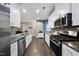 Modern kitchen with stainless steel appliances, white cabinetry and hardwood flooring at 605 Smallwood Dr, Durham, NC 27703