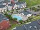 Aerial view of a community pool with lounge chairs, surrounded by well-maintained landscaping and colorful townhomes at 605 Smallwood Dr, Durham, NC 27703