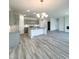 Bright open-concept kitchen and living room with grey wood-look floors at 67 Furley St., Homesite 117, Sanford, NC 27330
