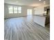 Open-concept living room with grey wood-look flooring that transitions to kitchen at 67 Furley St., Homesite 117, Sanford, NC 27330