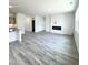 Open-concept living room featuring a fireplace and grey wood-look flooring at 67 Furley St., Homesite 117, Sanford, NC 27330