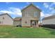 View of the home's rear exterior and yard, featuring double doors and a well-manicured lawn at 71 Herndon Ct, Clayton, NC 27520