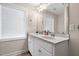Bright bathroom featuring a shower with patterned curtain, large mirror, and single sink vanity at 7107 Elkhorn Rd, Rocky Mount, NC 27803