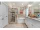 Bright bathroom featuring a glass-enclosed shower, soaking tub, and dual sink vanity at 7107 Elkhorn Rd, Rocky Mount, NC 27803