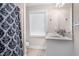 Bright bathroom featuring a shower with patterned curtain, large mirror, and single sink vanity at 7107 Elkhorn Rd, Rocky Mount, NC 27803