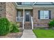 Charming brick home featuring a cozy front porch with white railing and inviting front door at 7107 Elkhorn Rd, Rocky Mount, NC 27803