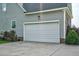 Close up on a two-car attached garage that features an automatic door, manicured landscaping, and driveway at 7107 Elkhorn Rd, Rocky Mount, NC 27803
