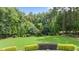 A large, meticulously maintained backyard with manicured lawns and mature trees provides privacy and natural beauty at 7410 Chouder Ln, Wake Forest, NC 27587