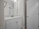 Close up of a bathroom vanity with white cabinets, a tiled backsplash, and modern fixtures at 7410 Chouder Ln, Wake Forest, NC 27587