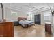 Large primary bedroom featuring trey ceilings, wood floors, and multiple windows for ample natural light at 7410 Chouder Ln, Wake Forest, NC 27587