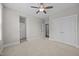 Bright, carpeted bedroom featuring a ceiling fan and access to closets and ensuite bathroom at 7410 Chouder Ln, Wake Forest, NC 27587