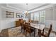 A charming dining room features hardwood floors, a modern chandelier, and large windows that provide ample light at 7410 Chouder Ln, Wake Forest, NC 27587