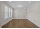 A versatile empty room with hardwood floors, neutral paint, and natural light offers endless possibilities at 7410 Chouder Ln, Wake Forest, NC 27587