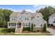 Charming two-story home with stone accents, manicured landscaping, and welcoming front porch at 7410 Chouder Ln, Wake Forest, NC 27587