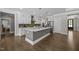 Modern kitchen with gray island, white cabinets, and stainless steel appliances at 7410 Chouder Ln, Wake Forest, NC 27587