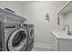 Well-equipped laundry room featuring modern washer and dryer and sink with storage at 7410 Chouder Ln, Wake Forest, NC 27587