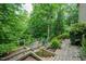Spacious backyard featuring terraced garden beds and a path leading through the greenery at 776 Legend Oaks Dr, Chapel Hill, NC 27517