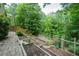 Backyard with multiple terraced garden beds, wooden steps, and lush greenery at 776 Legend Oaks Dr, Chapel Hill, NC 27517
