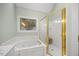 Bright bathroom featuring a soaking tub, a shower stall with gold trim, and a decorative window at 7808 Sandy Bottom Way, Raleigh, NC 27613