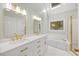 Bright bathroom features a double vanity with white countertops, gold fixtures, and a skylight at 7808 Sandy Bottom Way, Raleigh, NC 27613