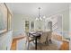Formal dining room with hardwood floors, elegant lighting, and a large window creating a sophisticated dining experience at 7808 Sandy Bottom Way, Raleigh, NC 27613