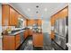 Another view of the kitchen showcasing stainless appliances, granite countertops, and the functional island at 7808 Sandy Bottom Way, Raleigh, NC 27613