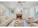 Comfortable living room with a brick fireplace, hardwood floors, and large windows providing plenty of natural light at 7808 Sandy Bottom Way, Raleigh, NC 27613