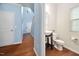 Powder room with pedestal sink, toilet, and window with blinds at 809 Davidson Point Rd, Cary, NC 27513