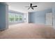 Bright bedroom featuring a ceiling fan, large windows, and built-in shelving at 809 Davidson Point Rd, Cary, NC 27513