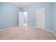 Cozy bedroom featuring soft blue walls, plush carpeting, and two entry doors for enhanced convenience at 809 Davidson Point Rd, Cary, NC 27513