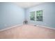 Comfortable bedroom with neutral walls, a pair of windows bringing in ample light, and plush carpeting at 809 Davidson Point Rd, Cary, NC 27513