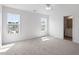 Bright bedroom with two large windows, neutral carpet, and an ensuite bathroom access offers comfort and convenience at 8326 Glenwood Springs Ct, Raleigh, NC 27616