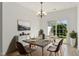 Bright dining room featuring modern lighting, table setting, and sliding glass door leading to the backyard at 8326 Glenwood Springs Ct, Raleigh, NC 27616