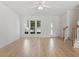 Spacious, bright living room with a ceiling fan, hardwood floors, and staircase in view at 8326 Glenwood Springs Ct, Raleigh, NC 27616