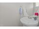 Powder room featuring a pedestal sink, round mirror, and neutral paint at 948 Consortium Dr, Raleigh, NC 27603