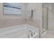 Bright bathroom features a soaking tub with tile surround and glass-enclosed shower at 948 Consortium Dr, Raleigh, NC 27603
