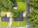 Aerial view of home with a black roof, green lawn, detached garage, and driveway in a tree-lined neighborhood at 1015 S 1St St, Smithfield, NC 27577