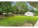 Expansive backyard featuring lush greenery, mature trees, and a detached garage, perfect for outdoor activities at 1015 S 1St St, Smithfield, NC 27577